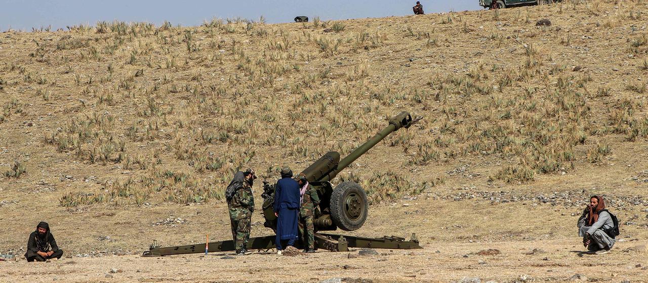 Taliban-Sicherheitskräfte stehen neben einer Artilleriekanone in der Nähe des Grenzgebiets im Bezirk Jaji Maydan, Afghanistan.