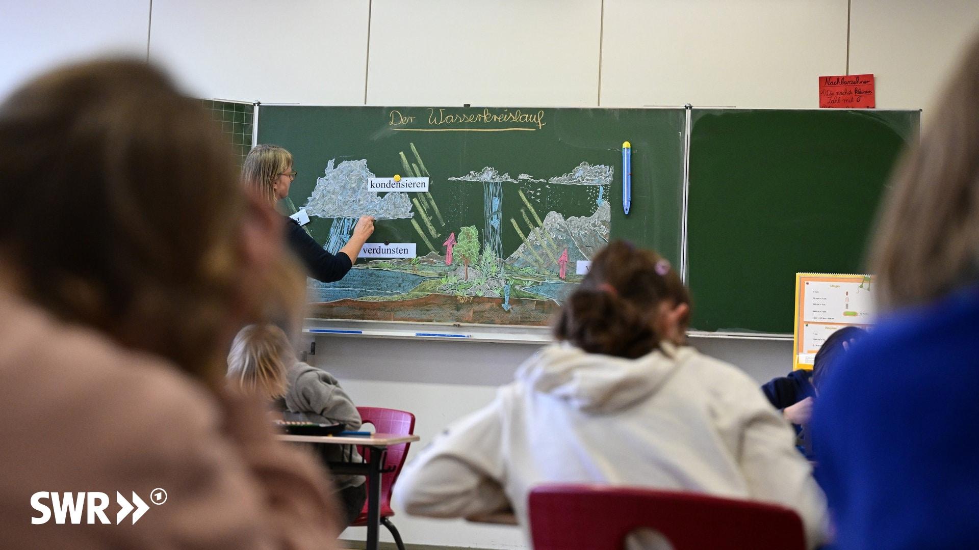 Eine Lehrerin erklärt der Klasse den Wasserkreislauf. Damit künftig weniger Unterricht ausfällt, fordern  Bildungsverbände mindestens 1.500 zusätzliche Lehrerstellen.
