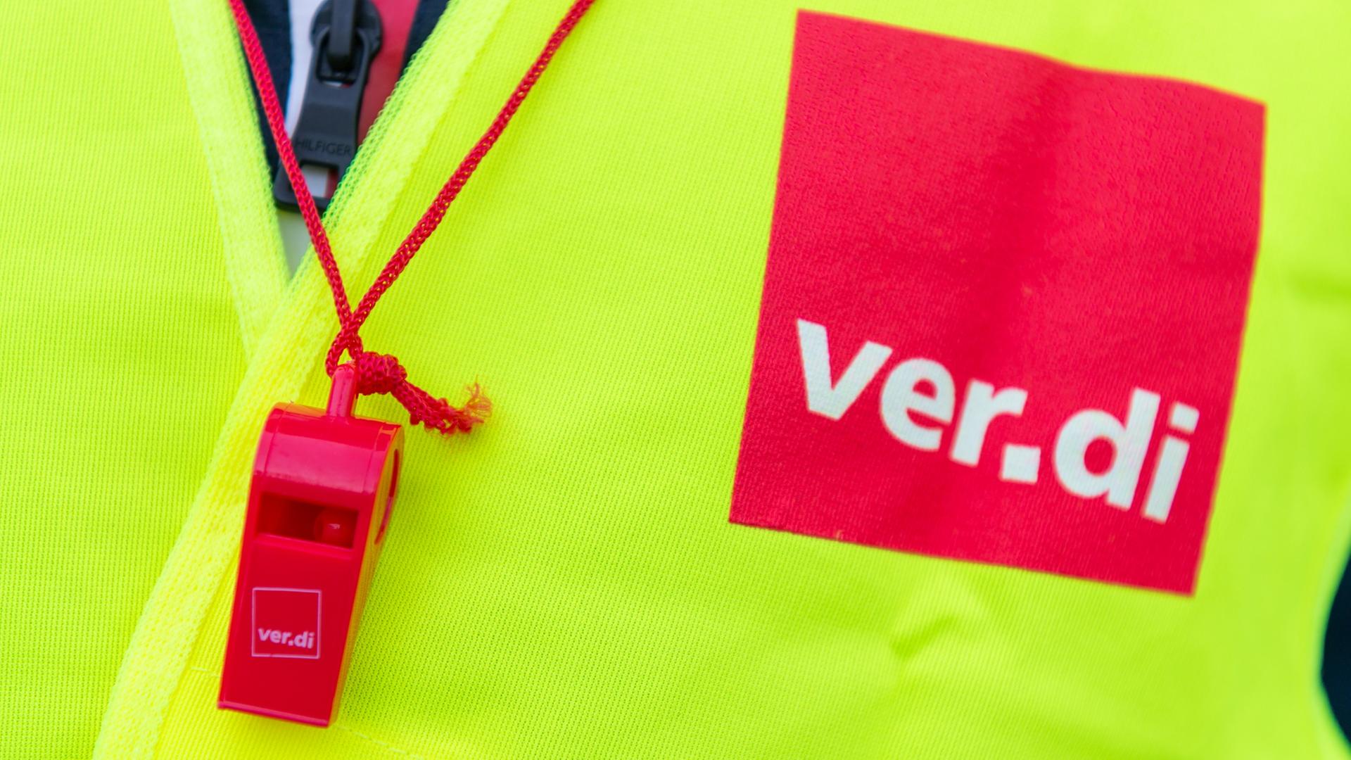 eine gelbe Warnweste mit dem Ver.di-Schriftzug und einer roten Trillerpfeife | dpa