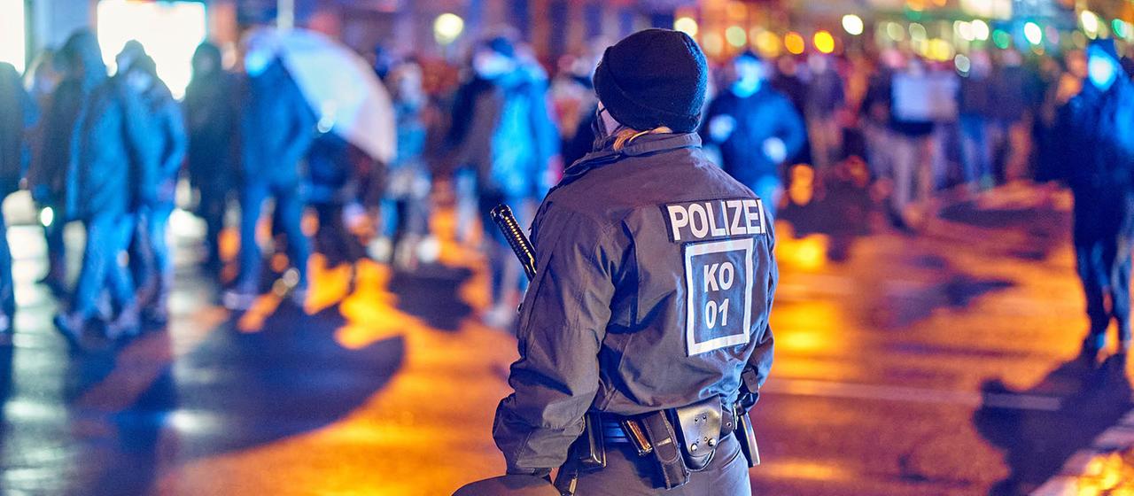 Polizeibeamte stehen am Rande einer Demonstration.