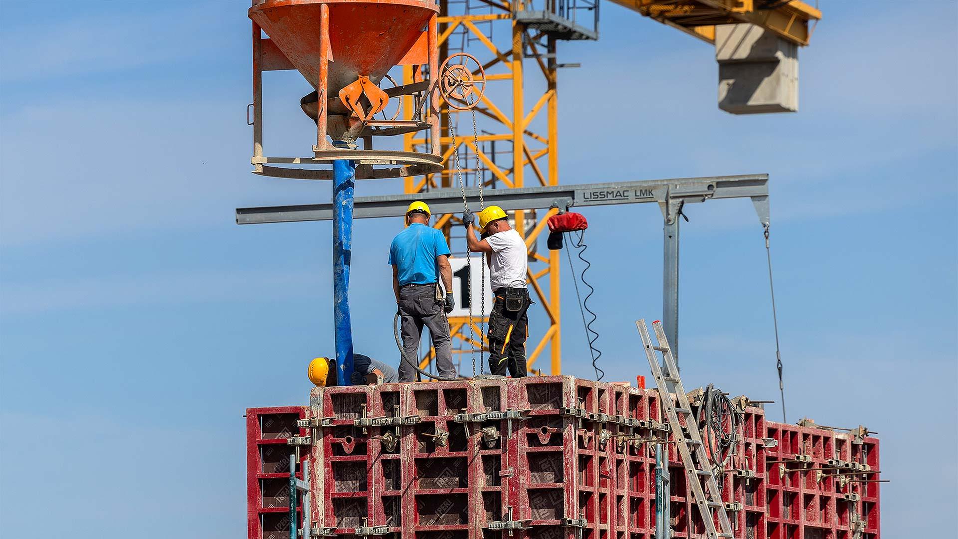 Bauarbeiter arbeiten an einem Rohbau für Eigentumswohnungen. | picture alliance/dpa