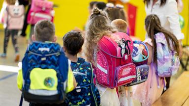 Schulkinder stehen bei der Einschulungsfeier in einer Grudschule.