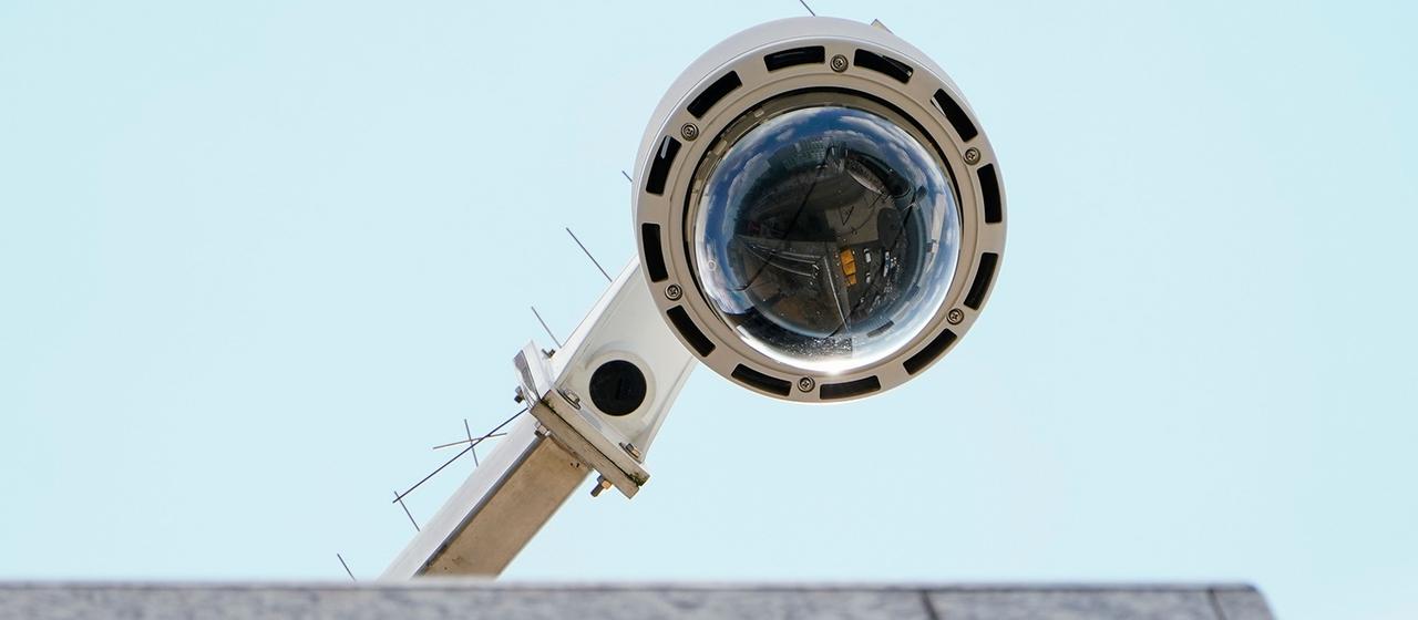 Eine Überwachungskamera ist an einem Gebäude befestigt. 