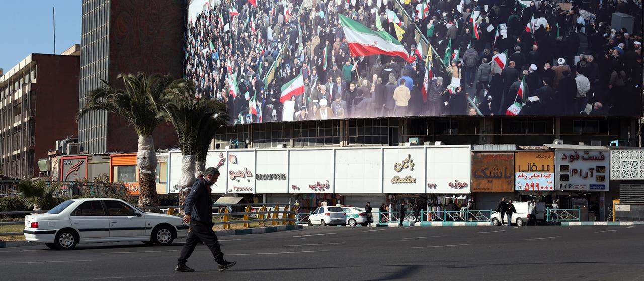 Iraner gehen auf dem Valiasr-Platz in Teheran, Iran, an einer Plakatwand vorbei.