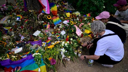 Menschen legen Blumen auf der Mahnwache für die Opfer des Anschlags auf dem CSD in Berlin nieder.