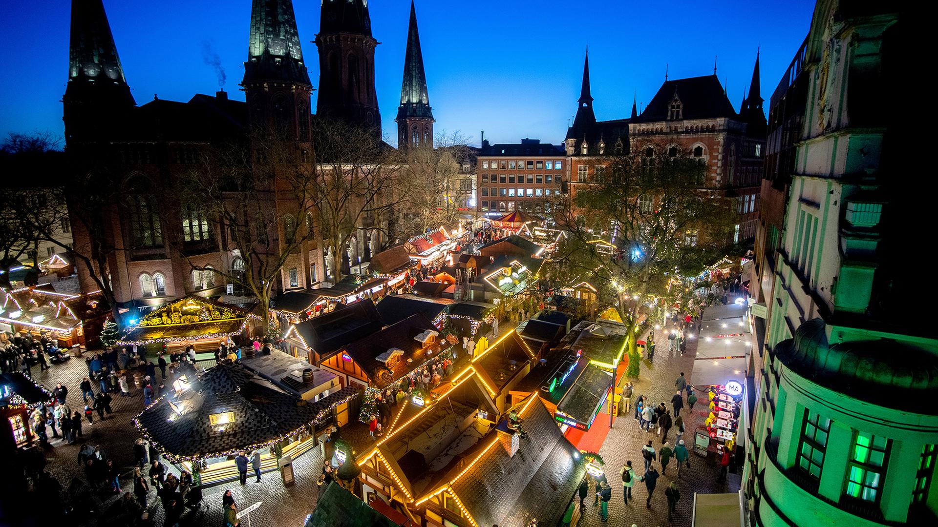 Besucher gehen über den Lamberti-Weihnachtsmarkt in der Innenstadt von Oldenburg. | dpa