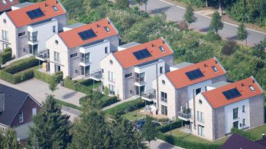 Fünf Wohnhäuser derselben Bauweise stehen nebeneinander.