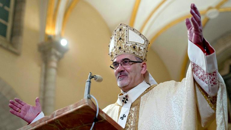 Der Lateinische Patriarch Pierbattista Pizzaballa hebt die Hände bei der Christmette in Bethlehem