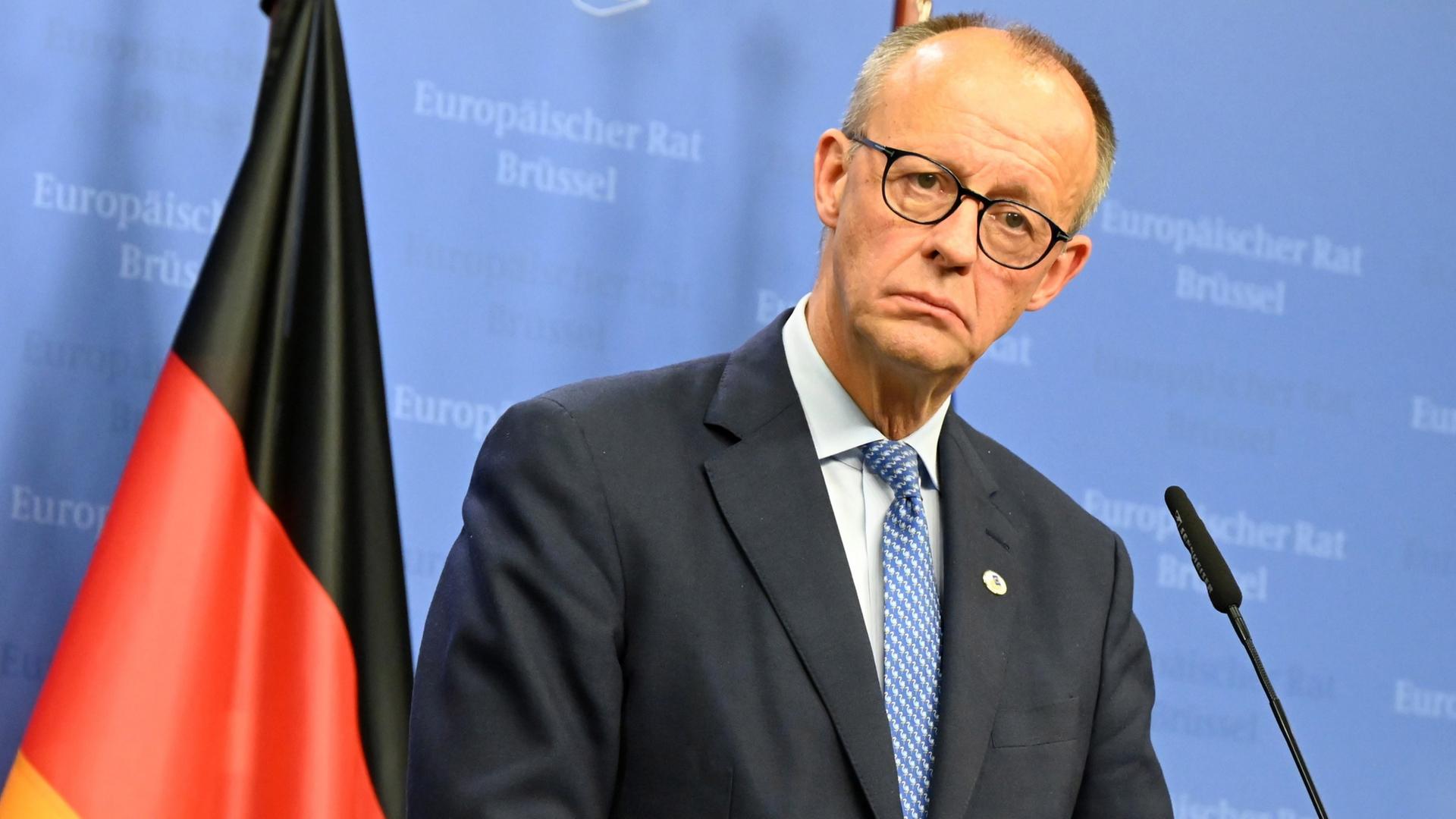 Friedrich Merz steht an einem Rednerpult, im Hintergrund die deutsche Flagge. | dpa