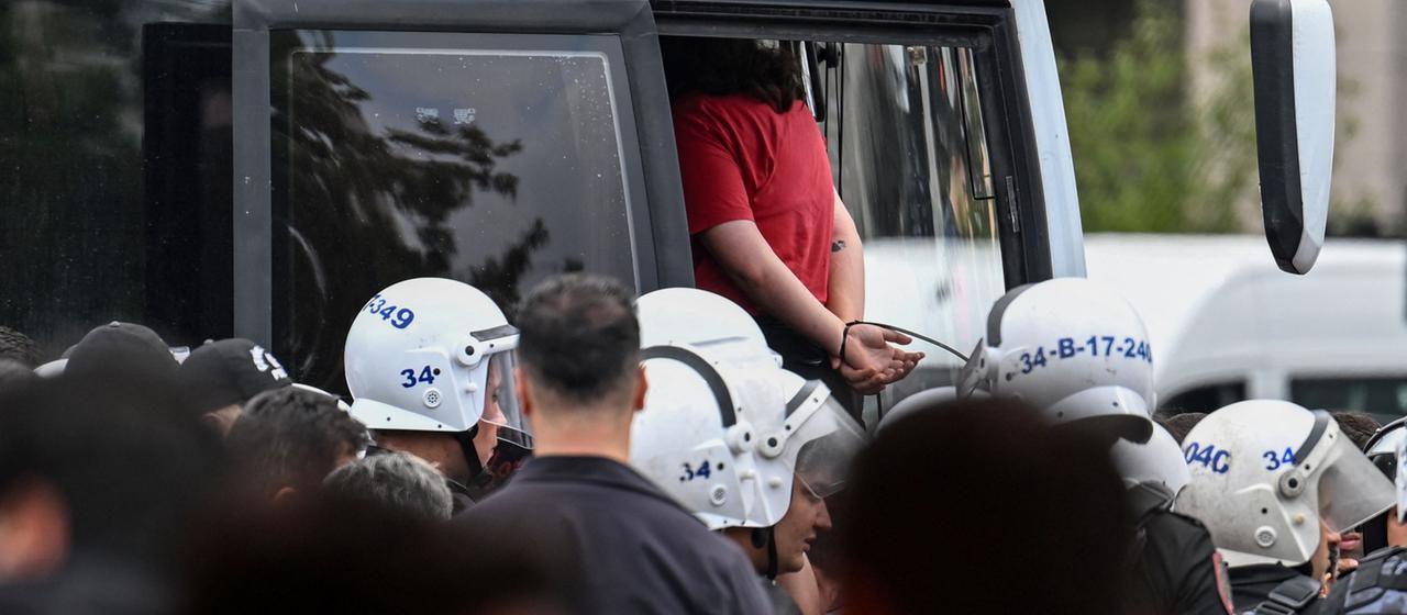 Eine verhaftete Person in der Türkei in einem Polizeibus.