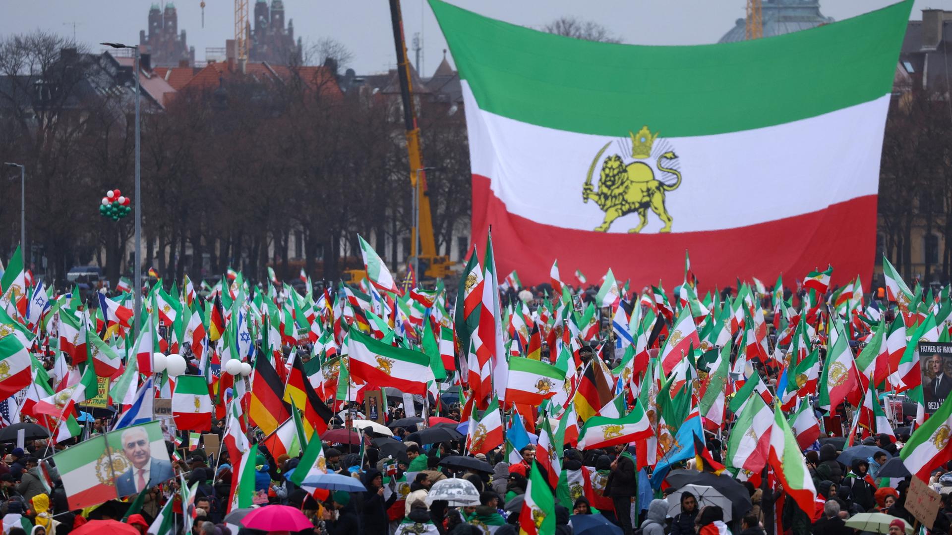 Menschen vor einer großen alten iranischen Staatsflagge | REUTERS