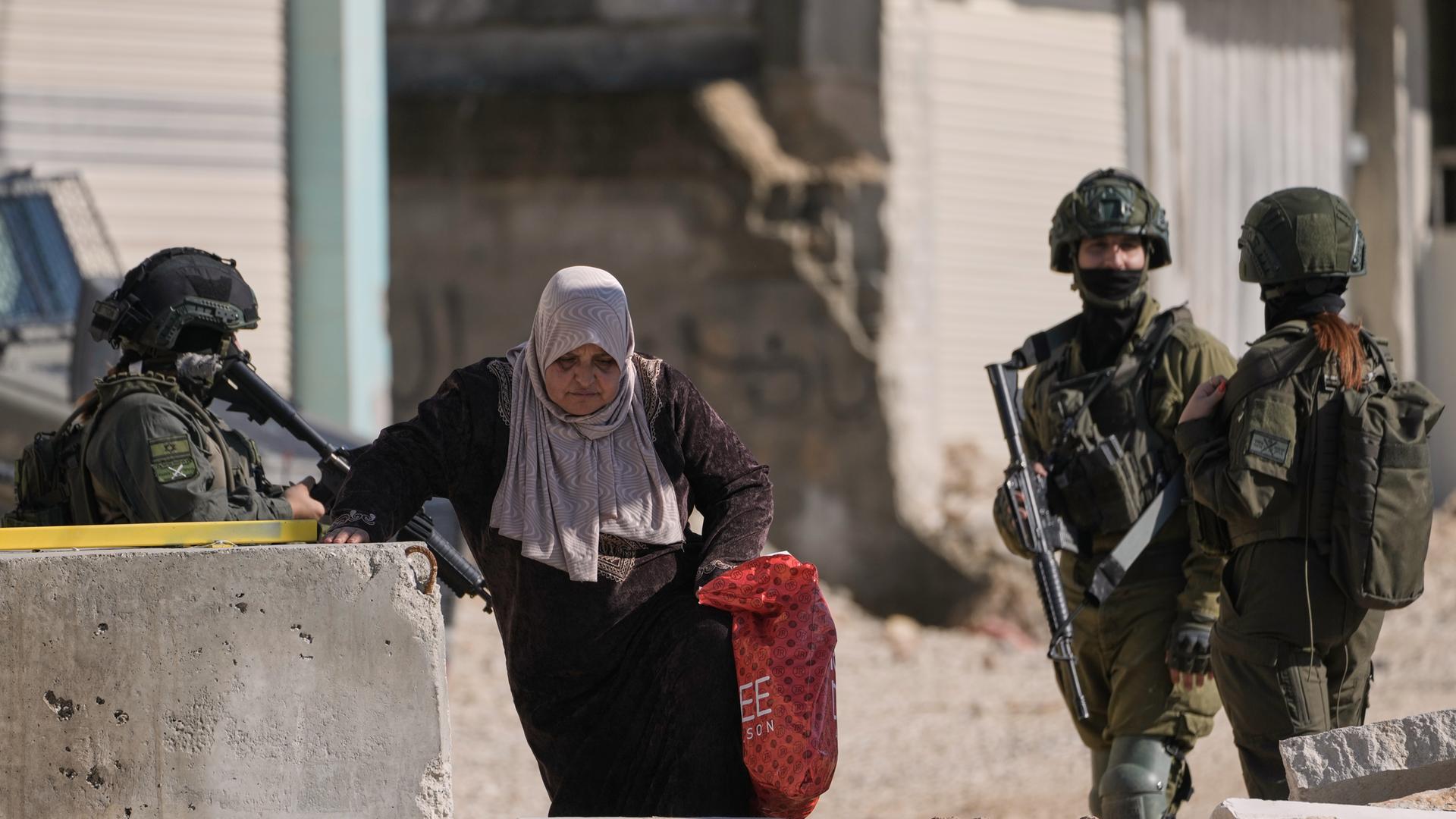  Tulkarem: Eine palästinensische Frau geht an israelischen Soldaten vorbei | dpa