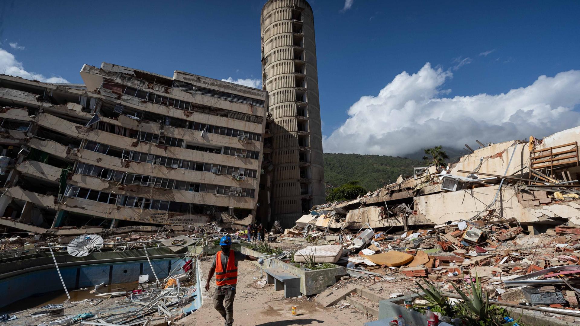 Ein Mann geht an zerst�rten Geb�uden in Venezuela vorbei. | EPA