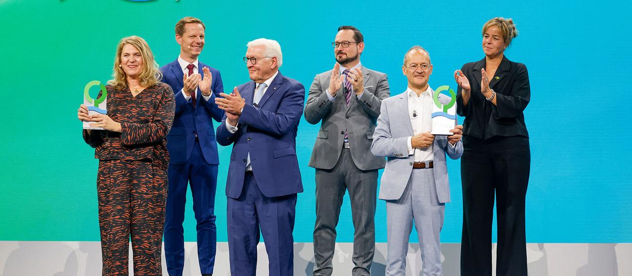 Preisträgerin Umweltjuristin Roda Verheyen (l-r), Kai Niebert, DBU-Kuratoriumsvorsitzender, Bundespräsident Frank-Walter Steinmeier, Alexander Bonde, Generalsekretär der DBU, Preisträger Membranfilter-Ingenieur Klaus Vossenkaul, und Mona Neubaur (Bündnis 90/ DIe Grünen), Ministerin für Wirtschaft, Industrie, Klimaschutz und Energie des Landes Nordrhein-Westfalen, stehen während der Verleihung des Deutschen Umweltpreises der Deutschen Bundesstiftung Umwelt (DBU) auf der Bühne