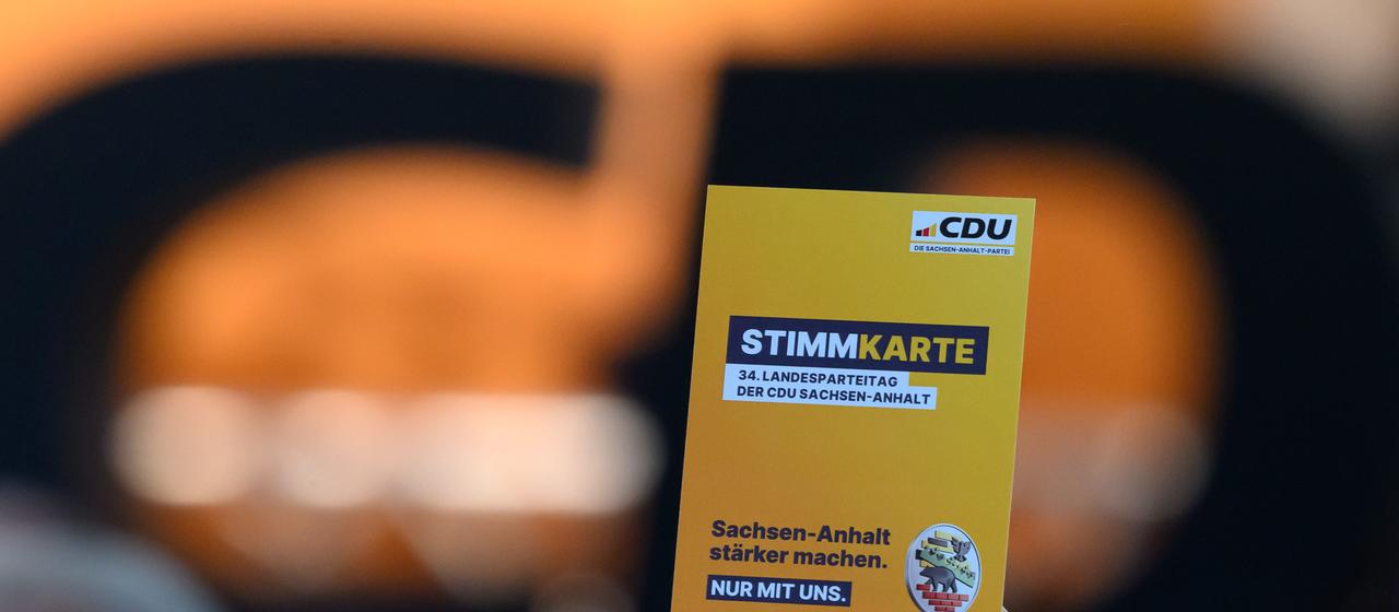CDU-Mitglied hält Stimmzettel beim Landesparteitag in Sachsen-Anhalt hoch.