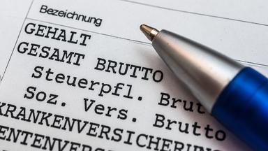 Ein Kugelschreiber liegt auf einer Gehaltsabrechnung.