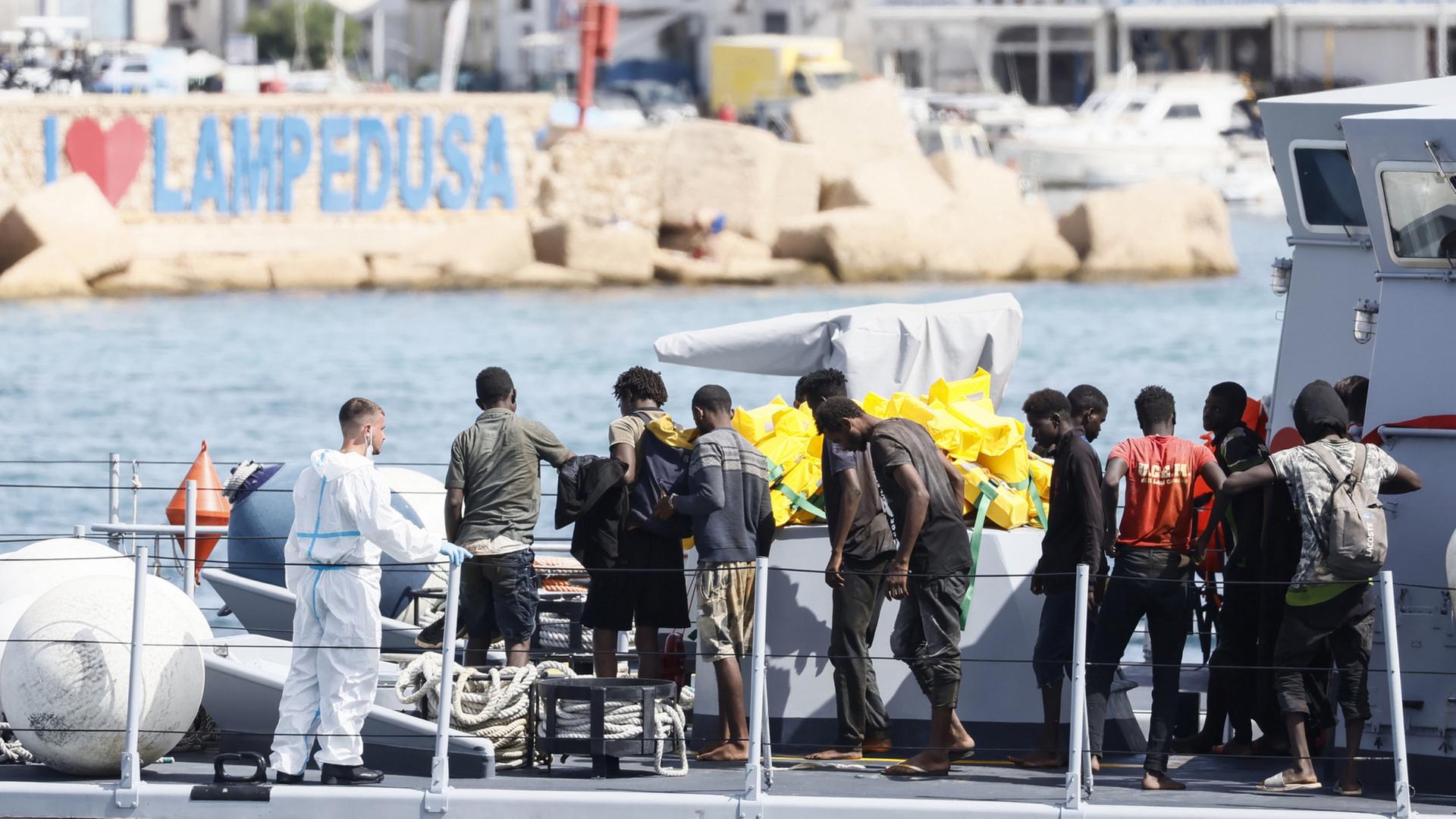 Gerettete Migranten stehen in einem Boot der italienischen Finanzpolizei, im Hafen der sizilianischen Insel Lampedusa in Süditalien. (Archivbild: 18.09.2023) | AP