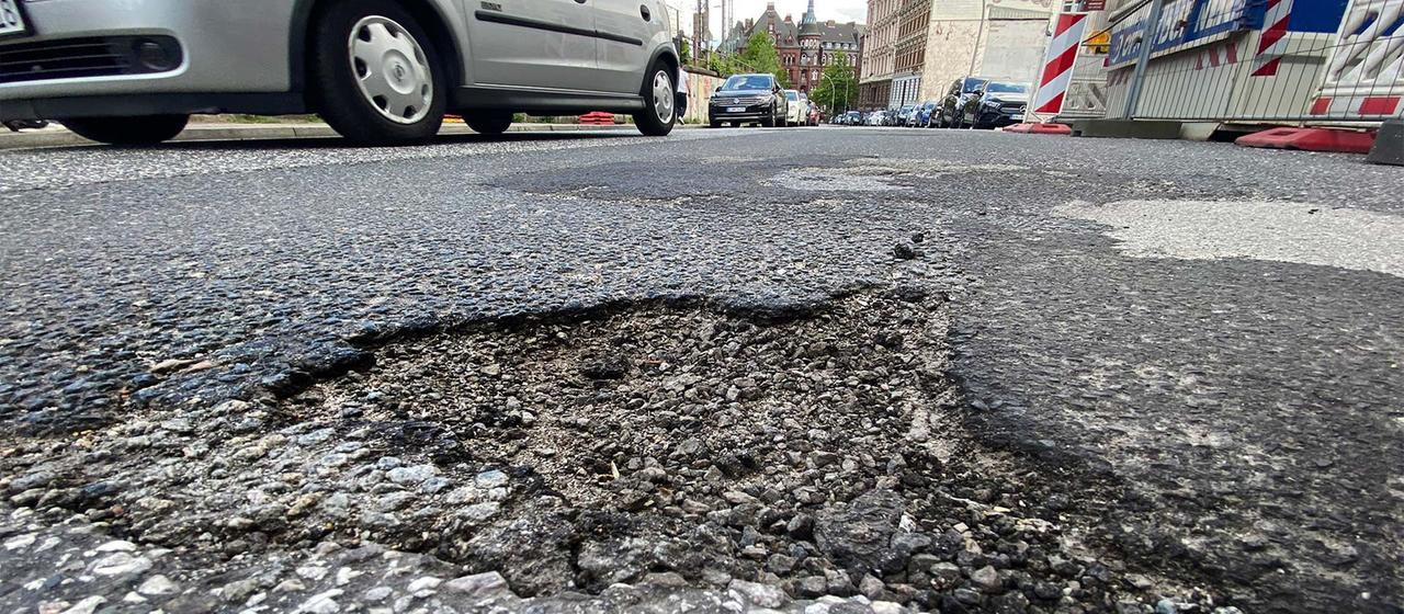 Ein Schlagloch auf einer Straße in der Hamburger Innenstadt. | picture alliance/dpa Ein Schlagloch auf einer Straße in der Hamburger Innenstadt.