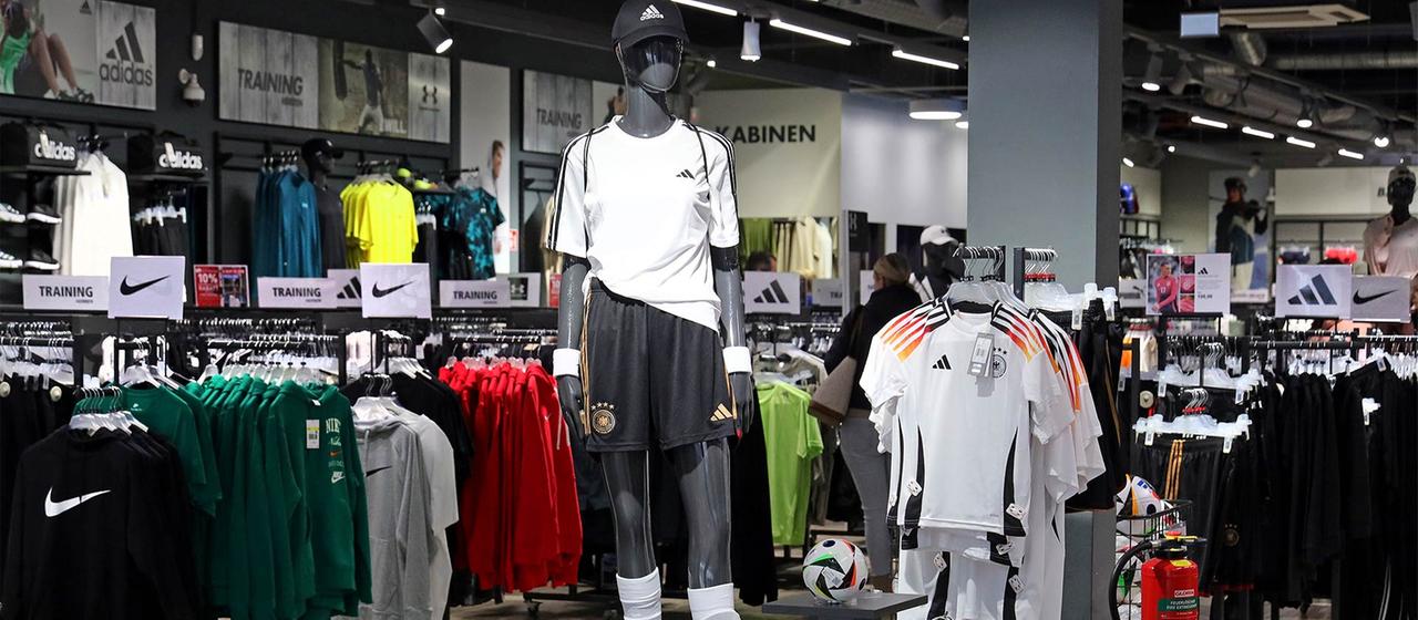Sportartikel von Adidas und Asics in einem Sportgeschäft.