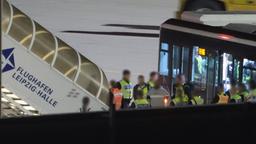 Einsatzkräfte und ein Bus stehen auf dem Vorfeld des Flughafens Leipzig/Halle.