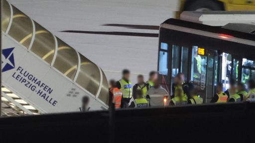 Einsatzkräfte und ein Bus stehen auf dem Vorfeld des Flughafens Leipzig/Halle.