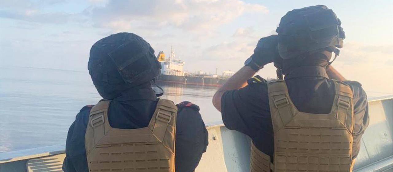 Zwei Mitglieder der Operation Atalanta der Europäischen Union beobachten vor der Küste Somalias im Arabischen Meer ein Schiff.