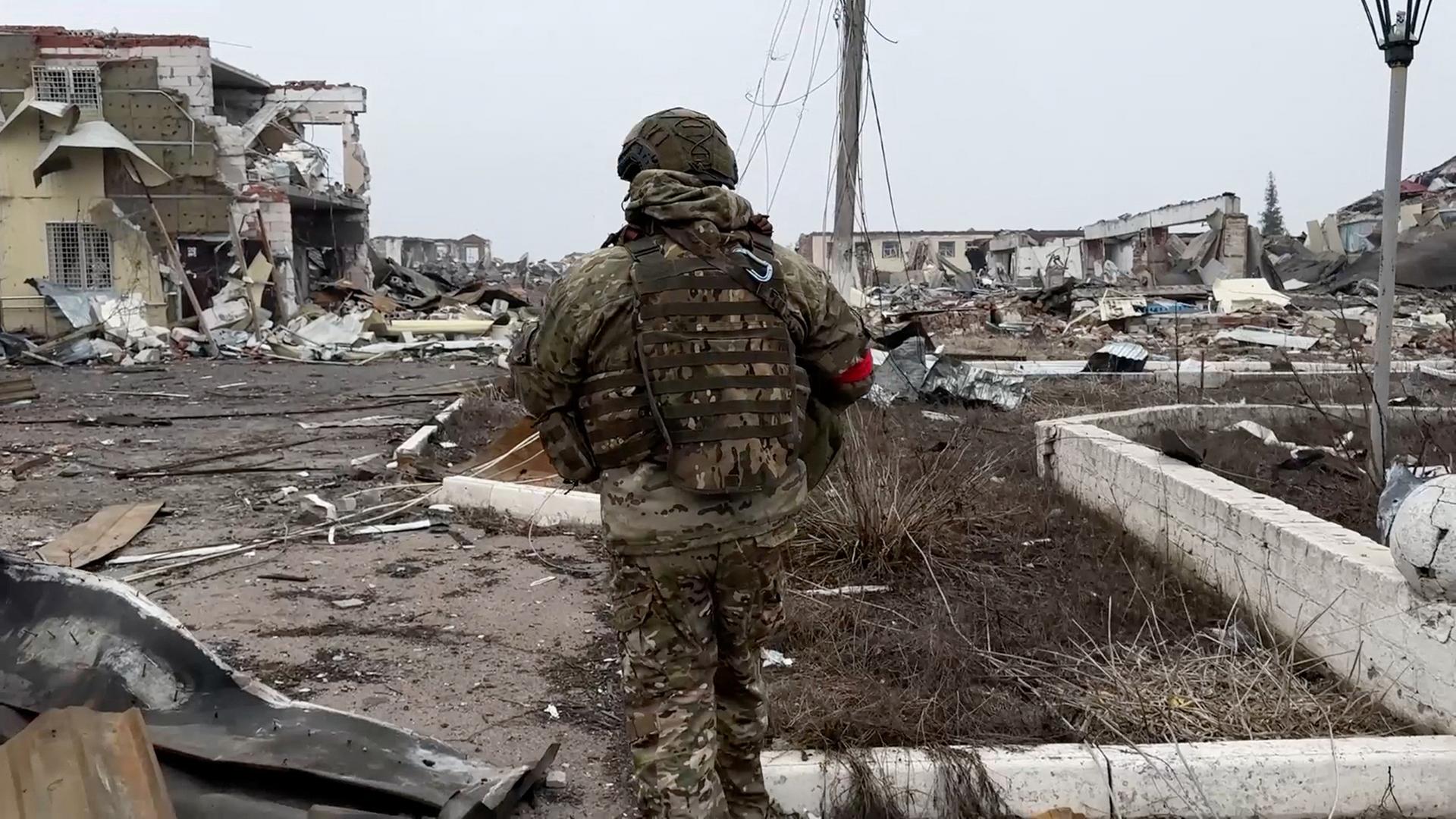 Ein Soldat der russischen Armee geht durch eine zerstörte Straße der Siedlung Malaya Loknya in der Region Kursk. | Russian Defence Ministry/Handout via REUTERS