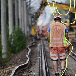 Ein Mann mit einer Weste, auf der Baggerfahrer steht, geht auf der Baustelle der Generalsanierung der Bahnstrecke zwischen Hamburg Berlin.