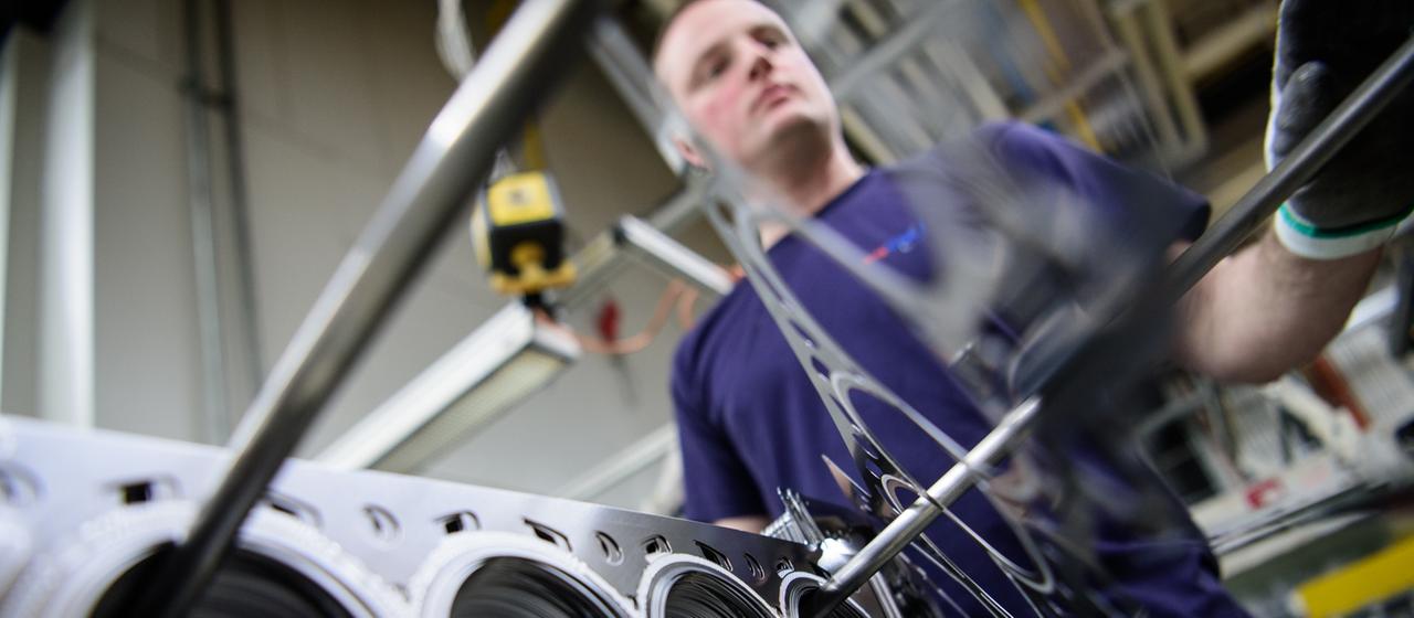 Ein Mitarbeiter eines Autozulieferers kontrolliert die Produktion der Zylinderkopfdichtungen (Symbolbild).