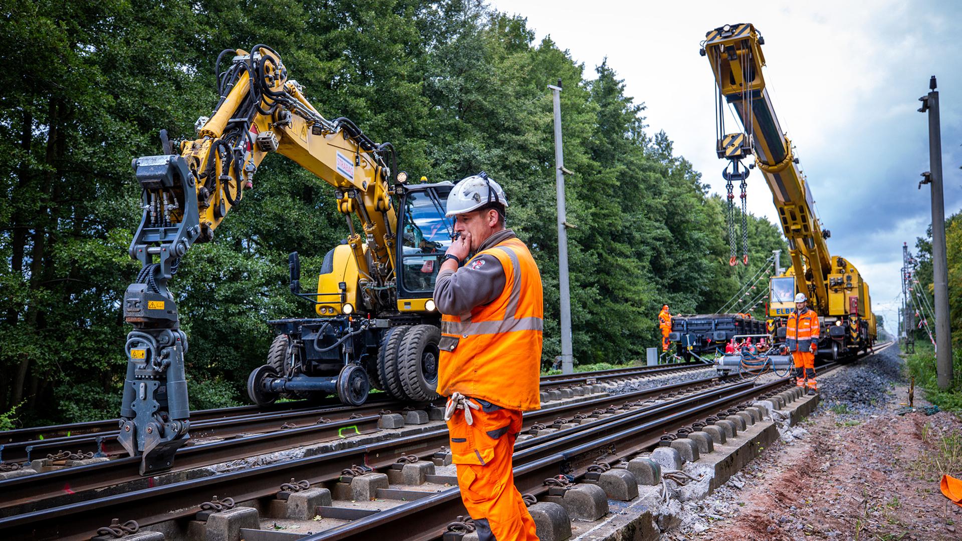 Mit schwerer Technik bauen Gleisarbeiter auf einem Teilstück der Bahnstrecke Hamburg-Berlin. | dpa