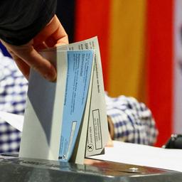 Eine Person gibt Stimmzettel in einem Berliner Wahllokal ab.