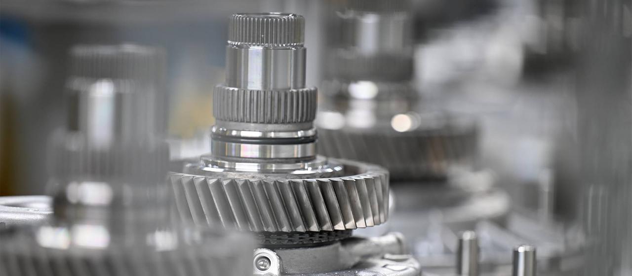 Wellen mit Getriebe-Zahnrädern liegen zur Montage bereit.