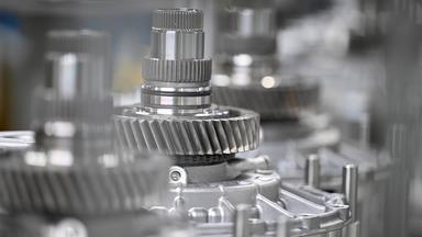 Wellen mit Getriebe-Zahnrädern liegen zur Montage bereit.