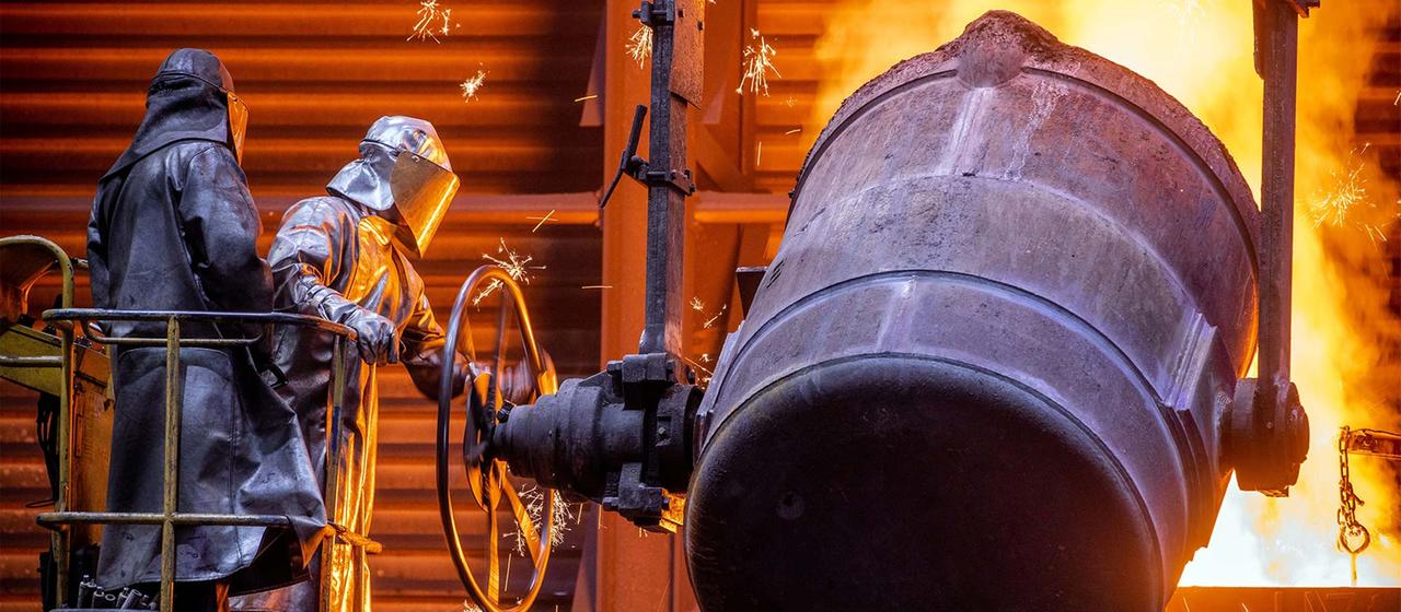 Arbeiter gießen flüssiges Eisen in der Eisengießerei Torgelow