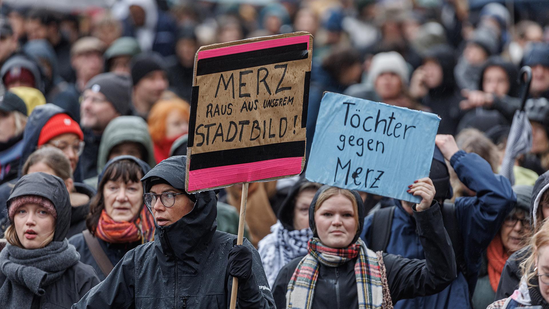 Teilnehmende halten auf einer Demonstration in Hamburg Schilder mit den Aufschriften