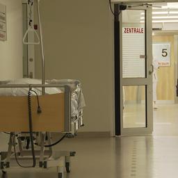 Der Gang zu einer Notaufnahme eines Krankenhauses. Direkt vor dem Eingang zur Notaufnahme steht ein leeres Krankenbett.