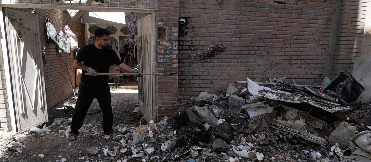 Ein Mann räumt Trümmer aus einem Gebäude, das beschädigt wurde in Teheran.