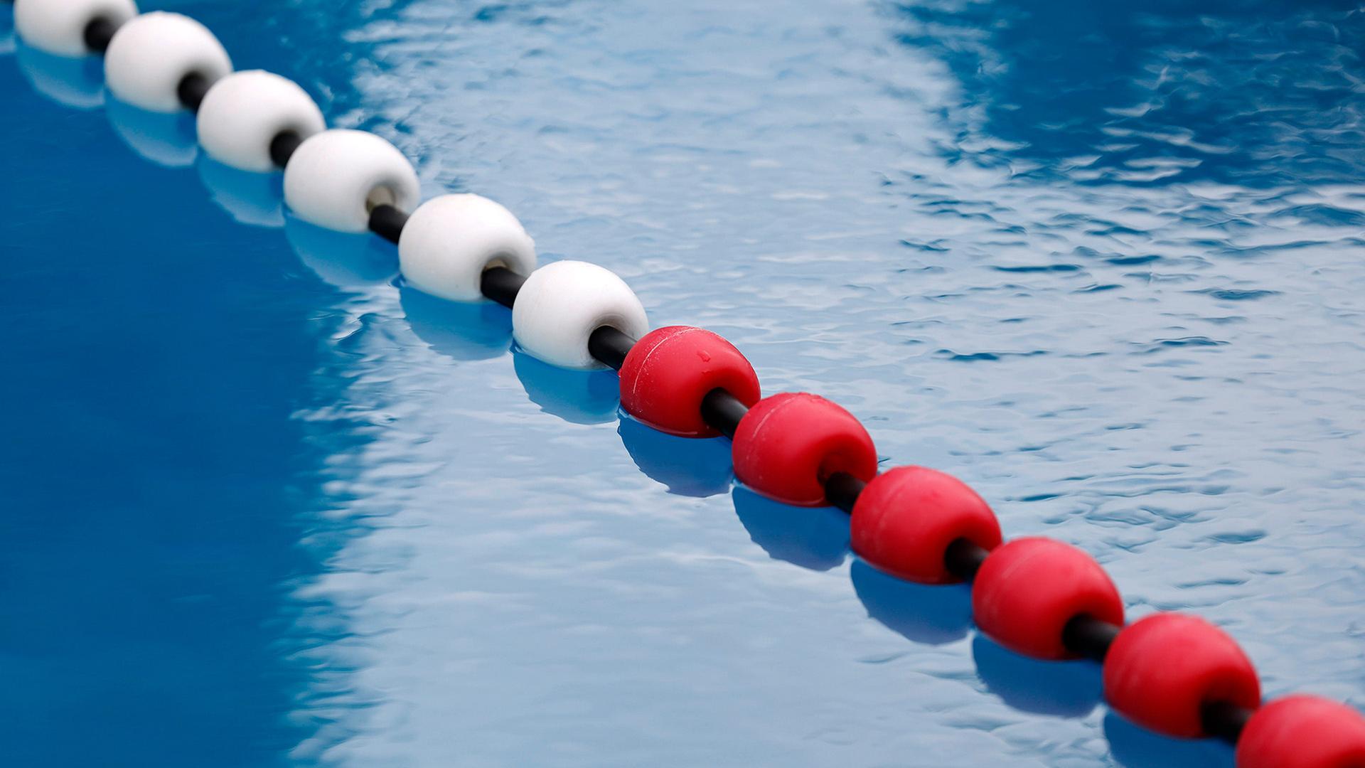 Blick auf die Schwimmleinen im Wasser des Sommerbads (Symbolbild, Quelle: Imago, Christoph Hardt) | www.imago-images.de