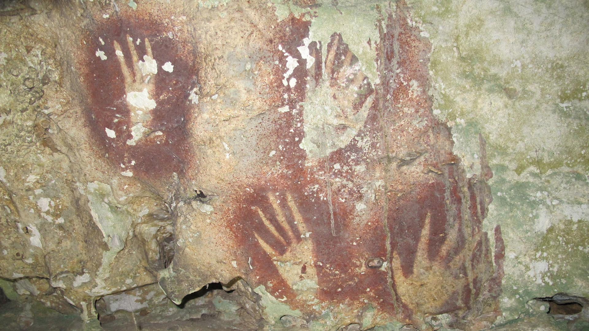 HandabdrÃ¼cke sind an einer HÃ¶hlenwand auf der Insel Sulawesi zu sehen. | AP