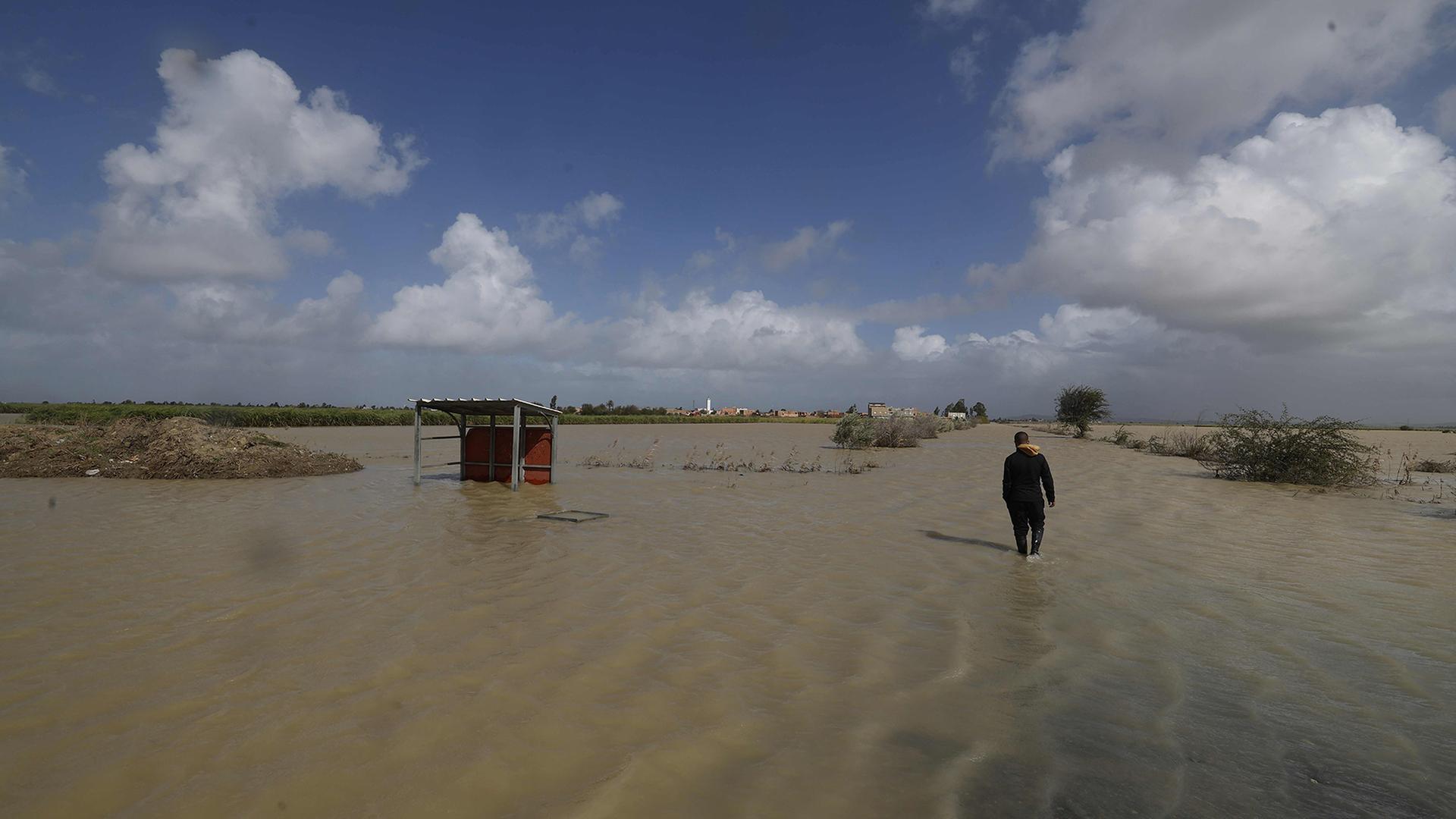 Ein Mann läuft auf einem von Hochwasser überfluteten Feld in der Region Sidi Slimane im Nordwesten Marokkos. (Archivbild: 13.2.2026) | AFP