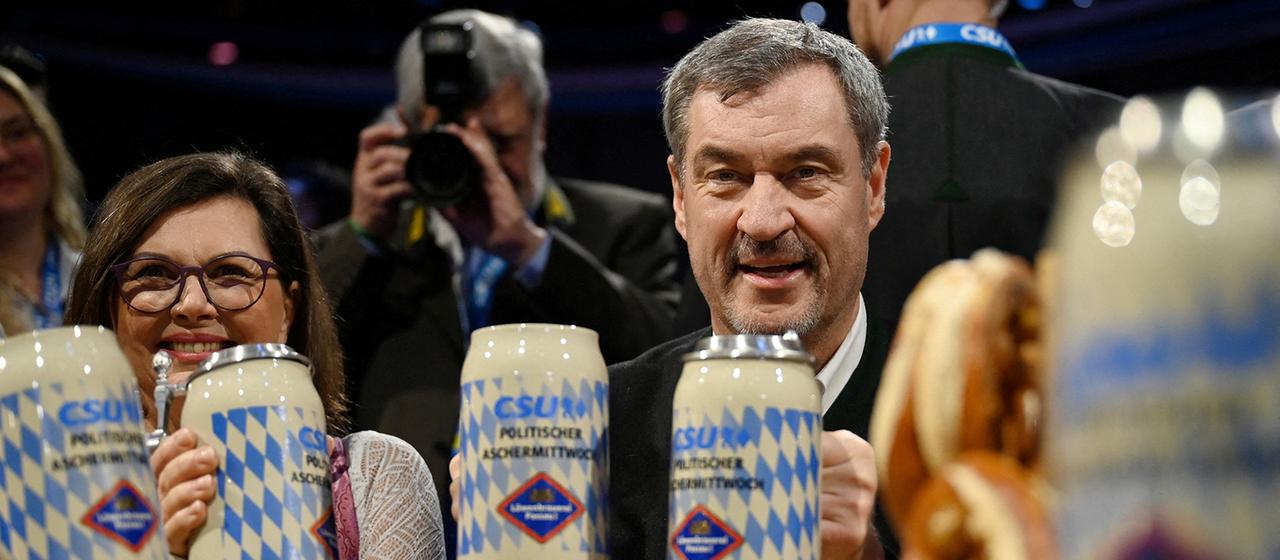 Markus Söder hebt während des traditionellen Aschermittwochstreffens der Partei in Passau einen Bierkrug