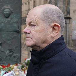 Olaf Scholz (rechts) und Reiner Haseloff vor Trauerblumen in Magdeburg