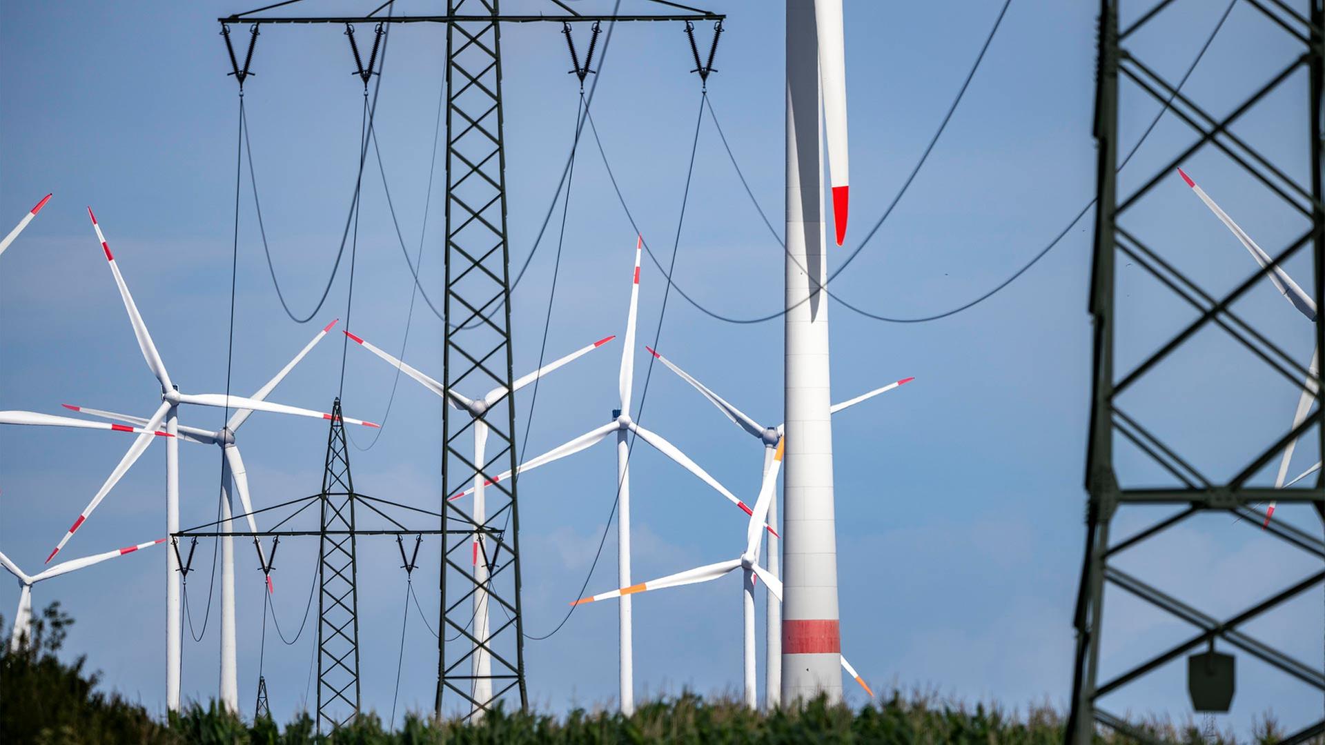 Strommasten und Windräder.