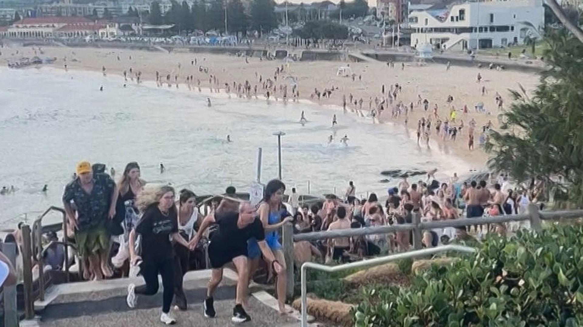 Menschen fliehen vom Bondi Beach in Sydney (Videostandbild). | AFP PHOTO / UGC / Mike Ortiz 