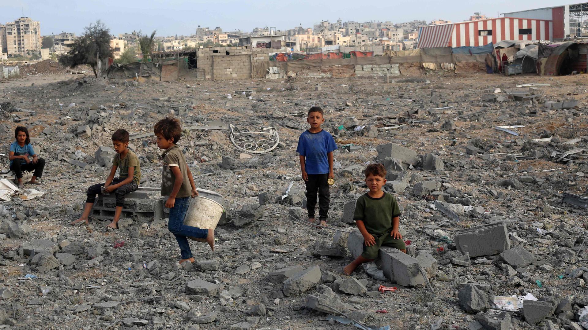 Palästinensische Kinder  inmitten von Trümmern im Flüchtlingslager Bureij im zentralen Gazastreifen. | AFP