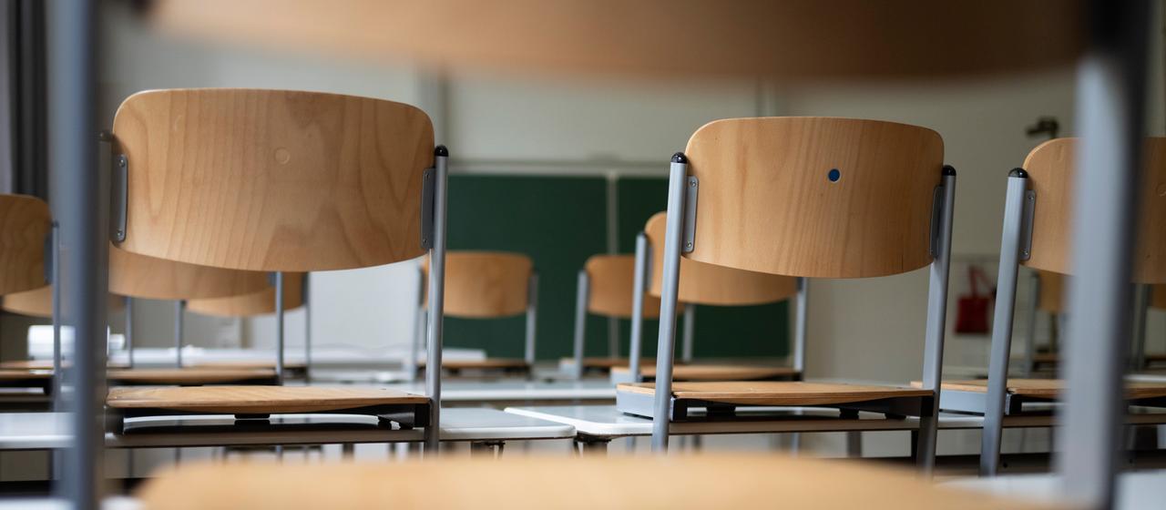 Stühle und eine Tafel sind in einem Schulraum eines Gymnasiums zu sehen. 