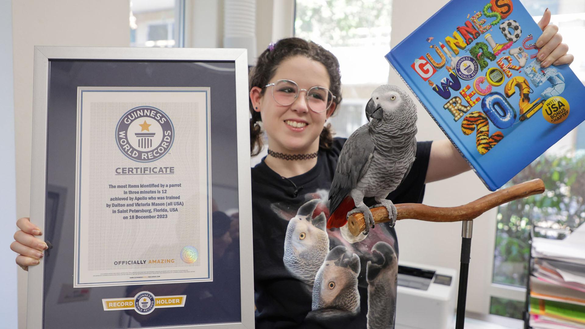 Victoria Mason mit der Urkunde und dem Buch der Guinness World Records, die ihrem Papagei Apollo verliehen wurden. | picture alliance / ZUMAPRESS.com