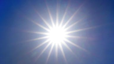 Die Sonne scheint am blauen Himmel.