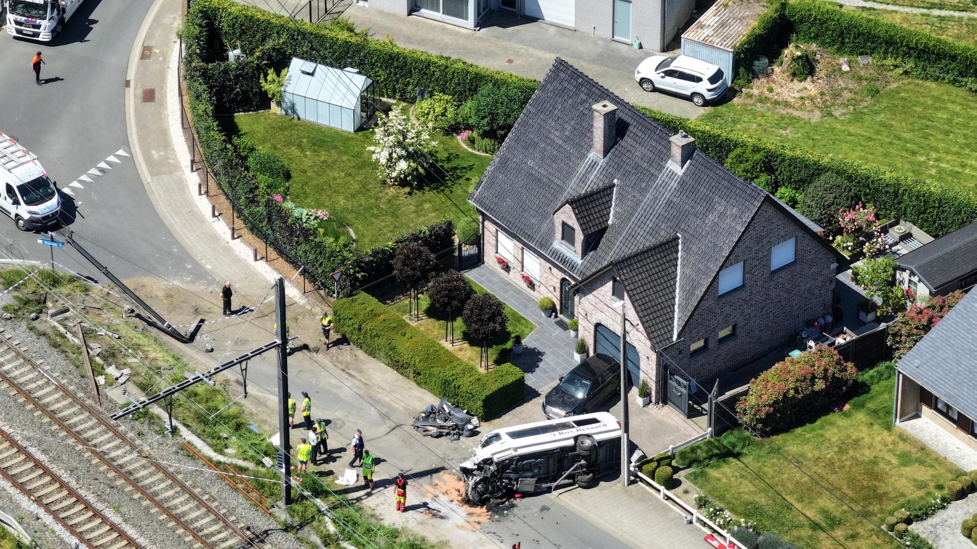 Rettungskräfte bei der Arbeit in der Nähe eines beschädigten Schulbusses in der Nähe der Stadt Buggenhout in Belgien. | REUTERS