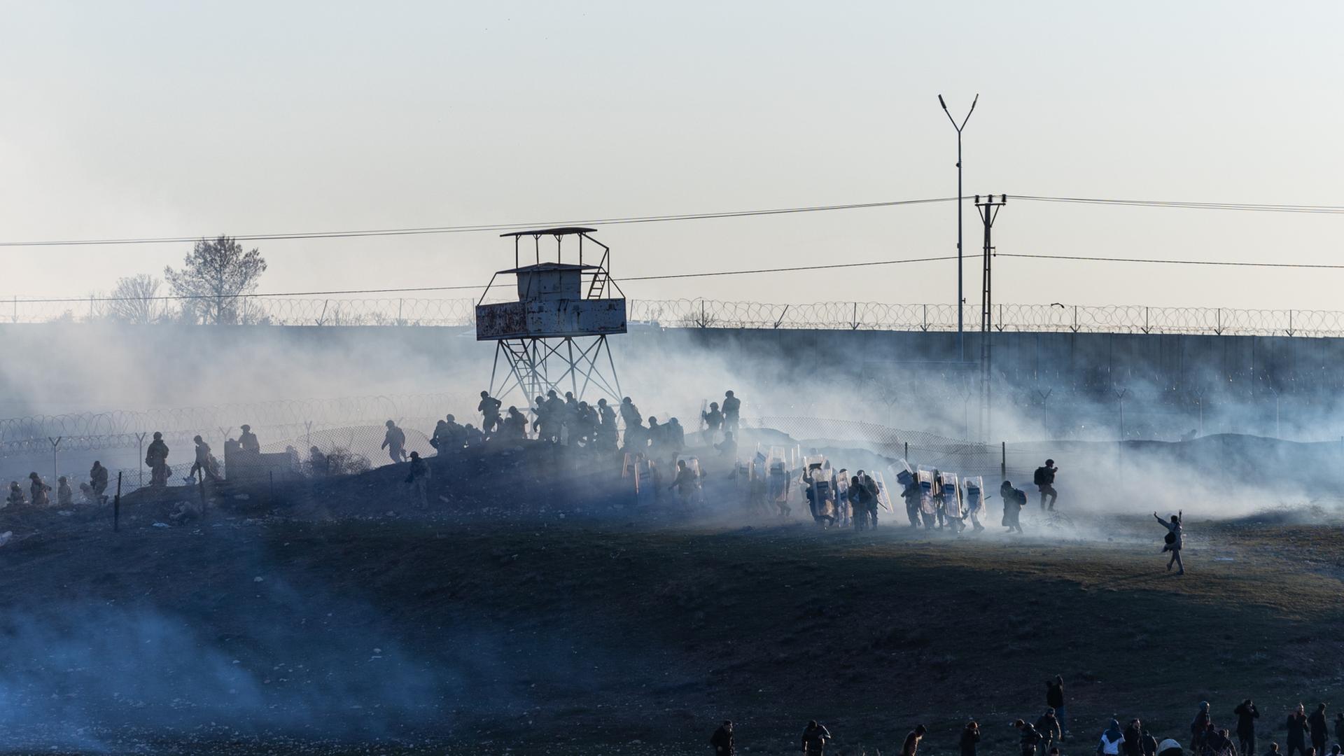 Pro-kurdische Protestierende und türkische Polizisten an der Grenze zu Syrien. | EPA